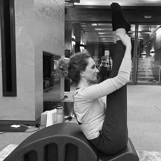 Andreea Fazacaș pe Spine Corrector, cu un picior întins vertical — fotografie alb-negru