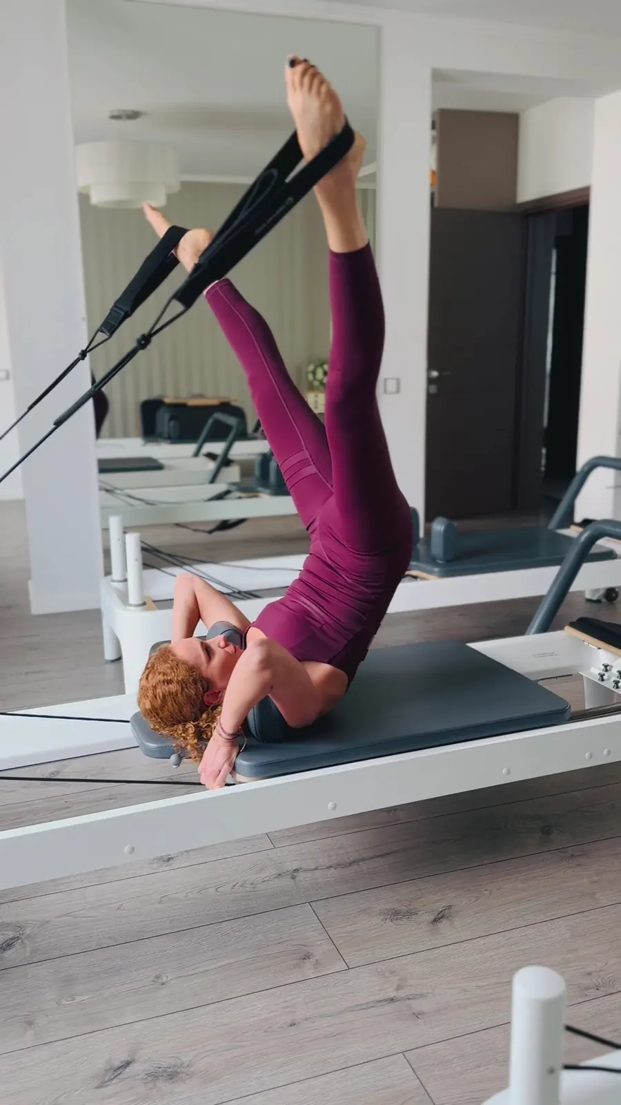 Andreea Fazacaș pe Reformer, cu picioarele în chingi, într-un exercițiu de control al trunchiului