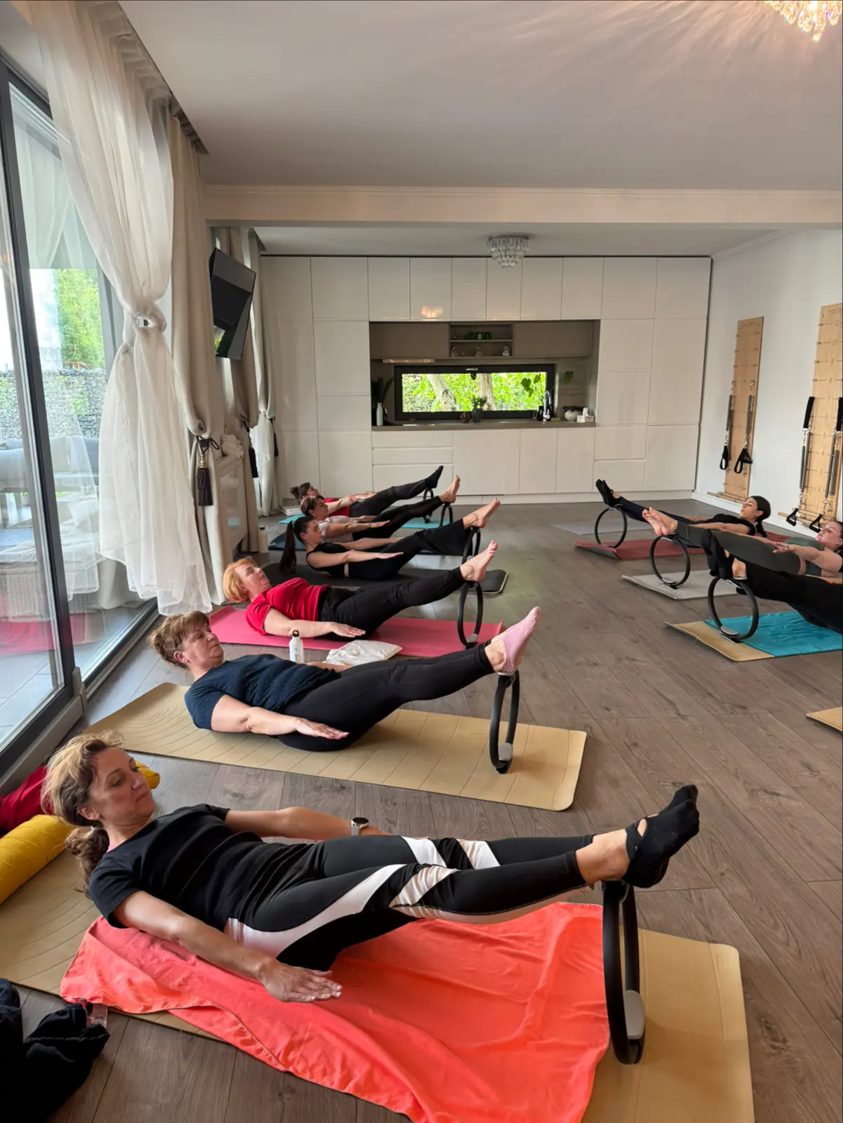 Sala studioului în timpul unei ore cu cercuri de pilates, lângă ferestrele mari